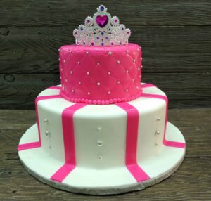 Treat your loved ones like a Princess! 2 tiered cake hand decorated with pink and white fondant and edible silver pearls. The cake includes a tiara cake topper! Please allow us 72 hours for your order!